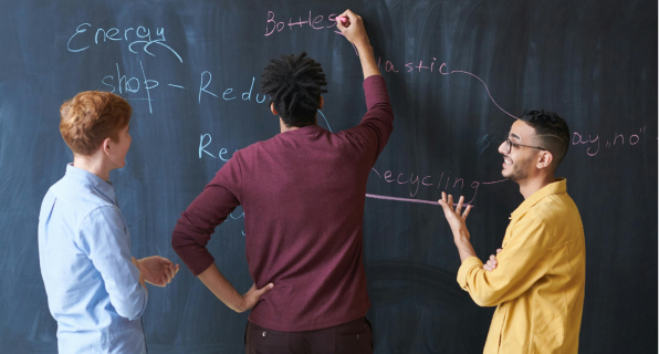 Three colleagues writing strategy on board