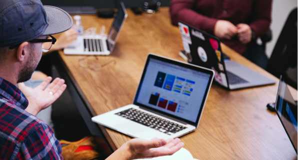 Employee presenting budget on a laptop to his team